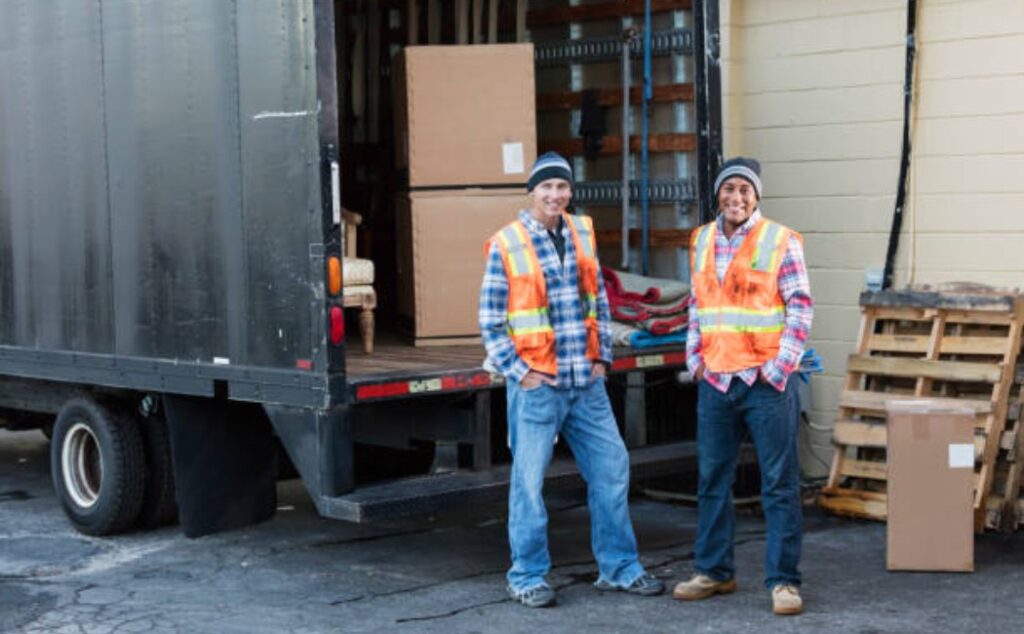 Two movers unloading boxes from a delivery truck