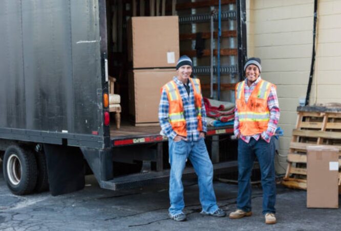 Two movers unloading boxes from a delivery truck