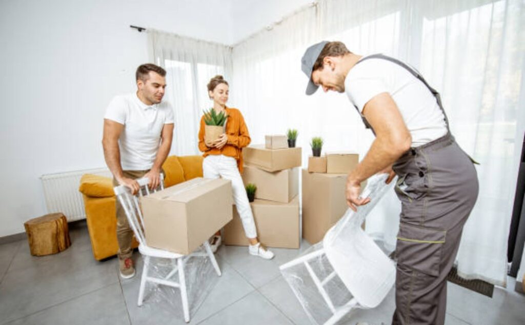 A young couple carrying boxes while moving into a new home