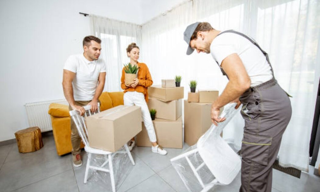 A young couple carrying boxes while moving into a new home
