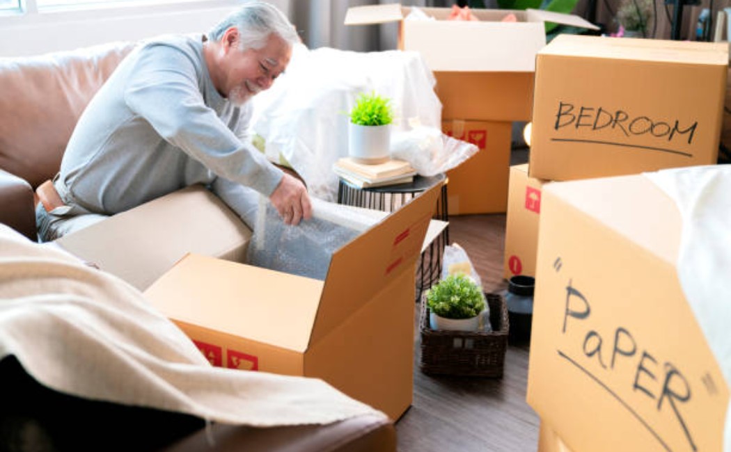 Senior man sitting on the floor during unpacking services session