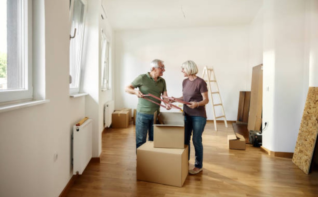 A mature man and woman unpacking in a bright living room