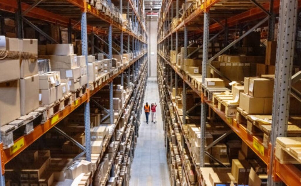 Team of workers walking down an aisle in a modern warehouse.