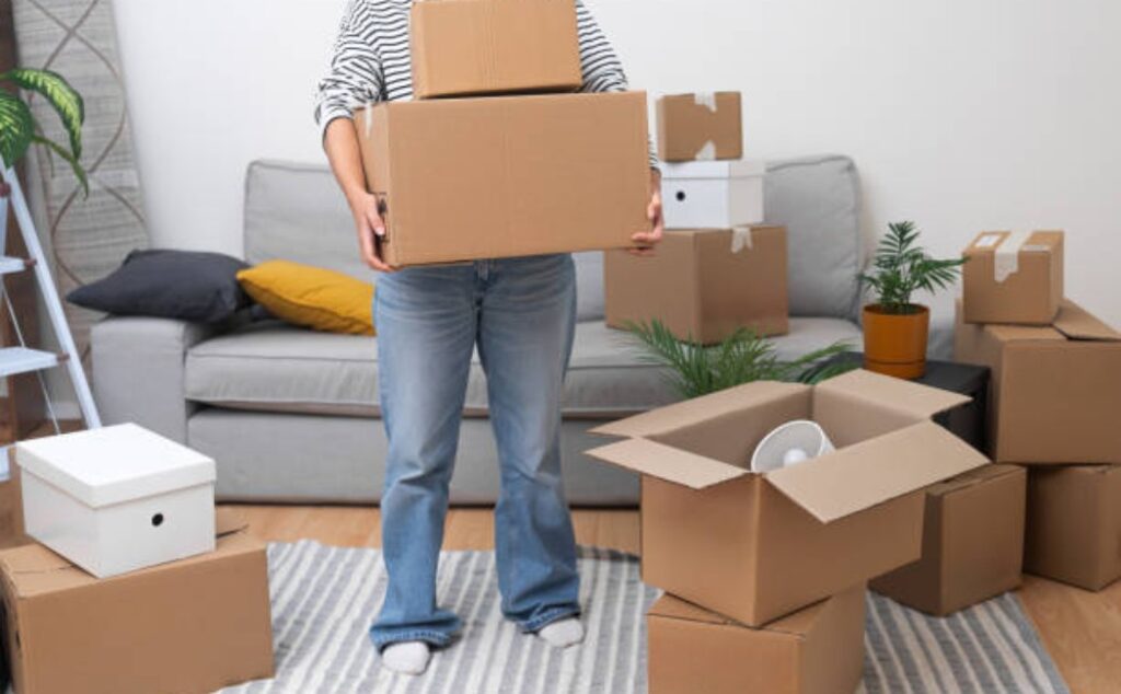 Female moving boxes during house relocation