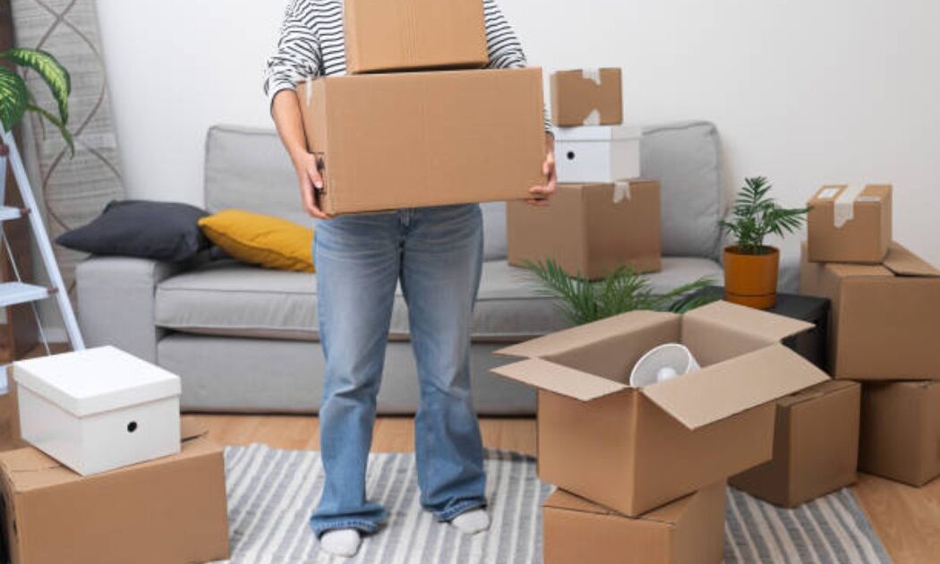 Female moving boxes during house relocation
