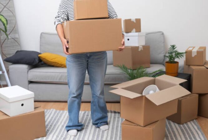 Female moving boxes during house relocation