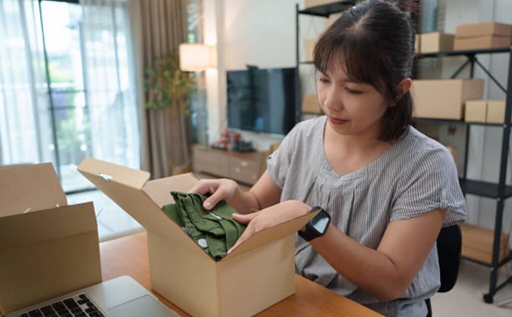 Woman handling online order packaging with green apparel.