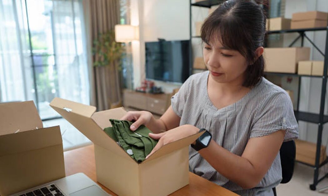 Woman handling online order packaging with green apparel.