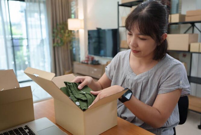 Woman handling online order packaging with green apparel.