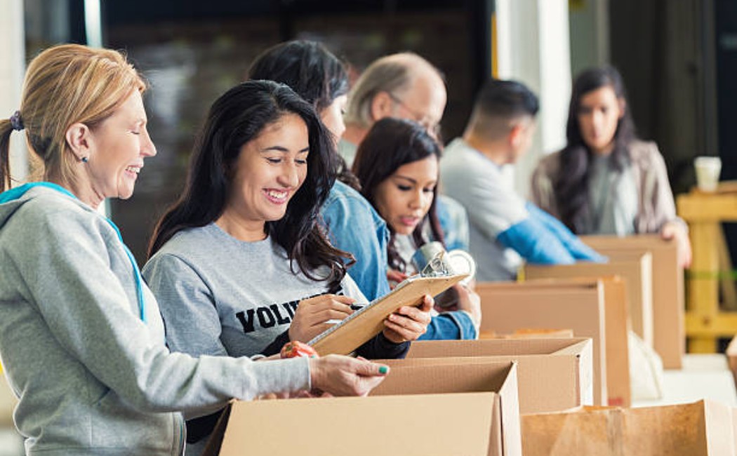 Community members packing boxes with non-perishable food items.