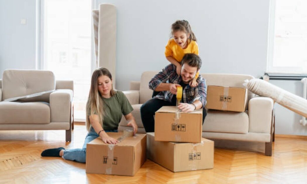 Family unpacking boxes and smiling in the new home
