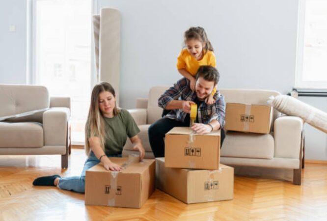 Family unpacking boxes and smiling in the new home