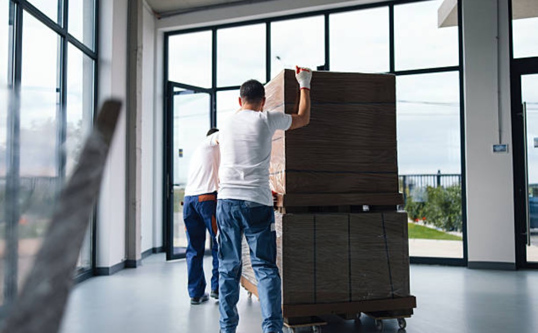 Office team moving large boxes during setup.