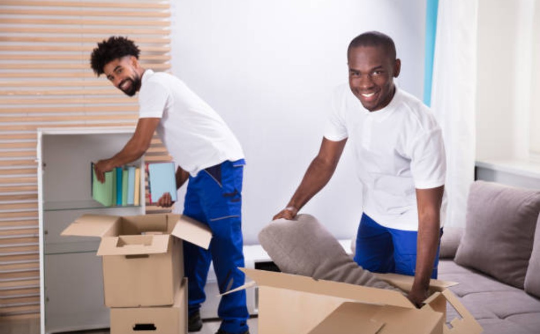 Movers unpacking cardboard boxes in a home