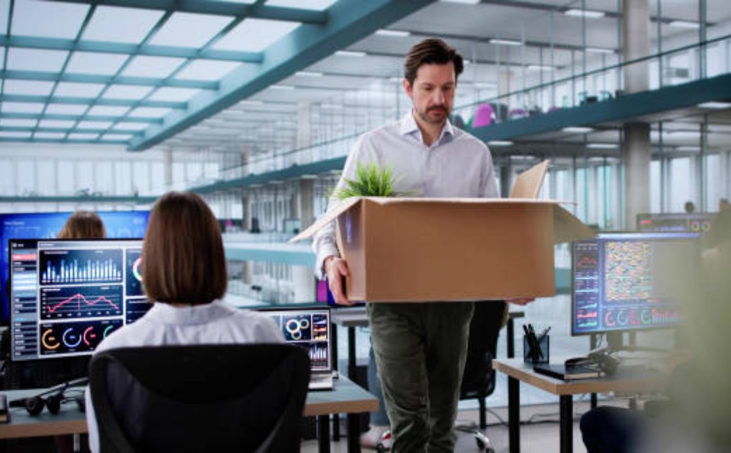 Office worker leaving job with a cardboard box of items.